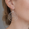 Boucles d’oreilles spirales en argent, style bohème chic, design circulaire artisanal, portées à l’oreille