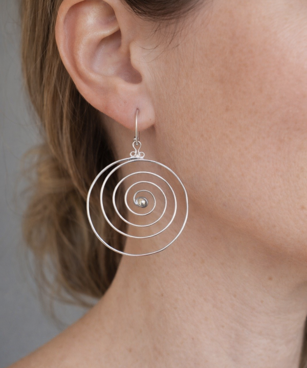 Boucles d’oreilles spirales en argent, style bohème chic, design circulaire artisanal, portées à l’oreille