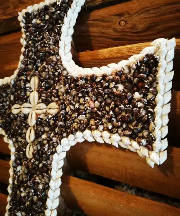 Croix artisanale de Bali en coquillages noirs, blancs et cauris crème.