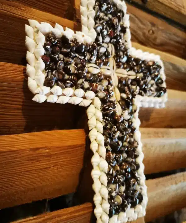 Croix artisanale de Bali en coquillages noirs, blancs et cauris crème.