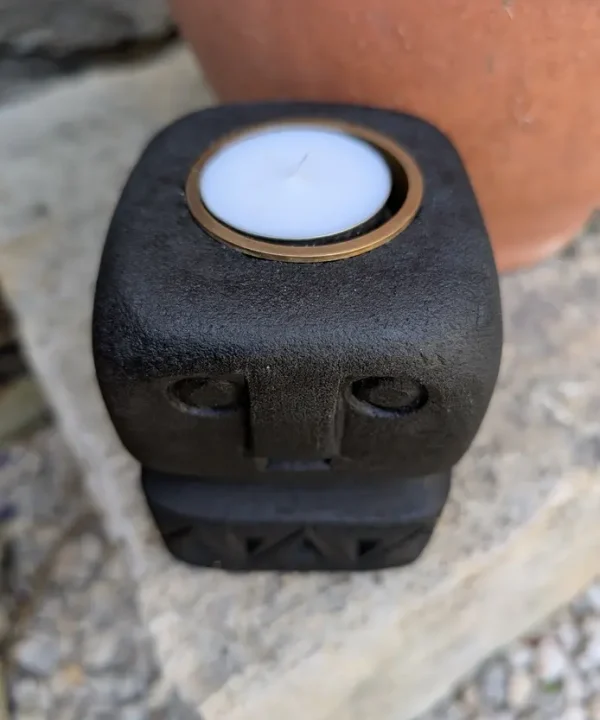 Bougeoir Sumba noir en grès, sculpture artisanale visage tribal protecteur.