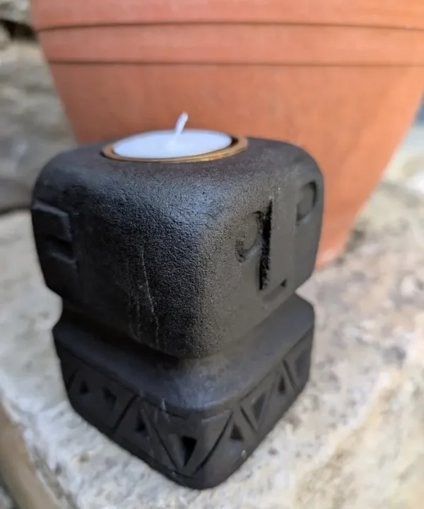 Bougeoir Sumba noir en grès, sculpture artisanale visage tribal protecteur.