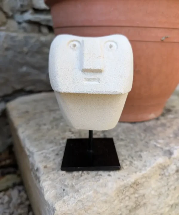 Statuette artisanale Sumba en grès beige, visage abstrait géométrique sur socle noir.